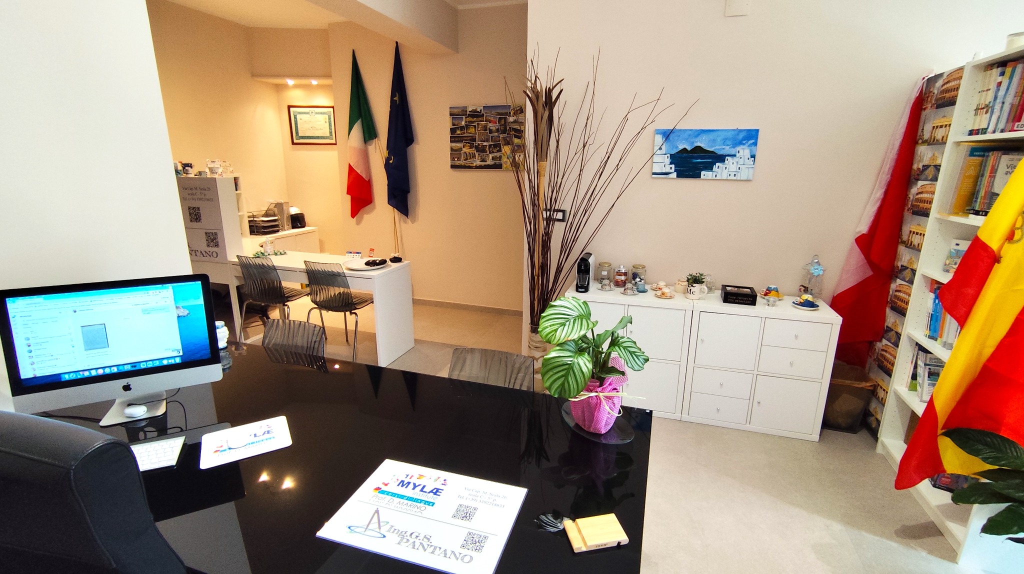 Sala didattica con scrivania, librerie e bandiere